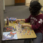 Rosa Garcia, Culinary Arts, 18, works on a couple of superhero-themed puzzles at the exhibit in the library.